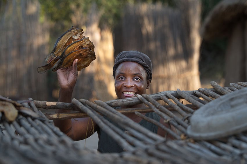 Frau zeigt getrockneten Fisch, Namibia