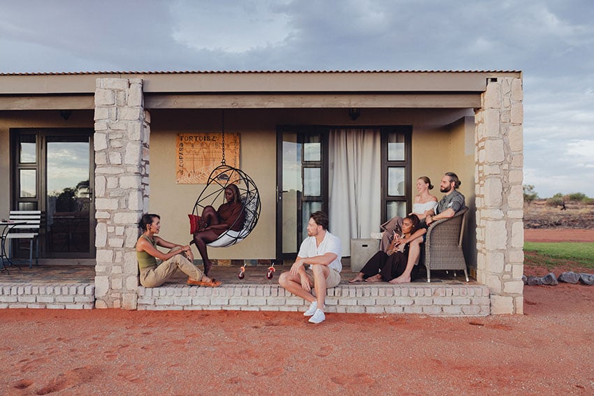 Young people in front of bungalow at Kalahari Anib Lodge, Namibia