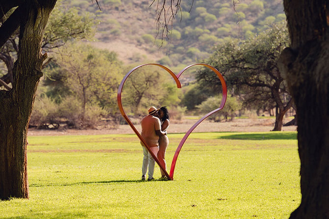 Couples kisses in heart photo frame, Okapuka Safari Lodge, Namibia