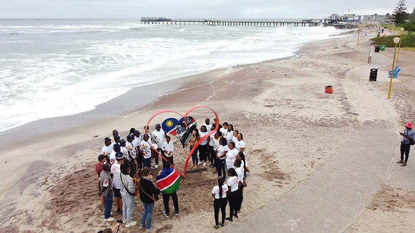 Group of Namibians, heart, beach, Swakopmund web