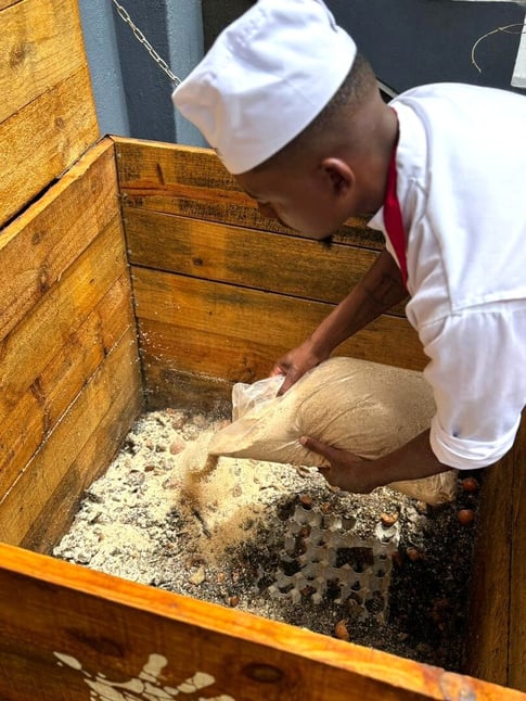 The Delight Swakopmund team during Vermicomposting Initiative pouring food waste and kitchen scraps in compost box