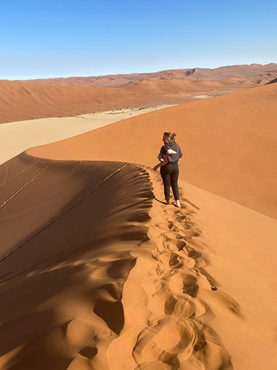 Woman with backpack on high dune, Sossusvlei, Namibia