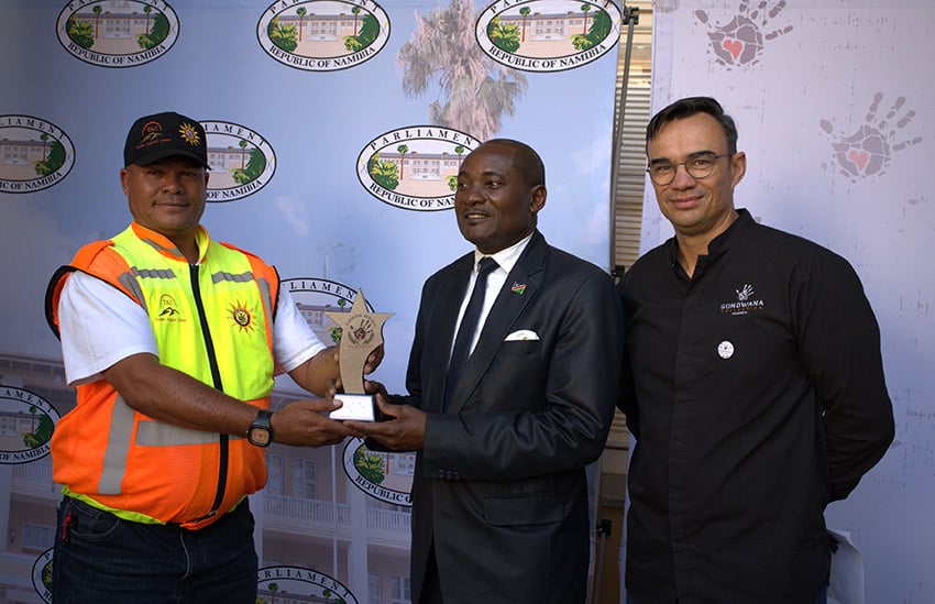 Minister Shifeta handing over the Tourism Heroes award to Peter Boer from Tourism Against Crime; right: Gys Joubert, Gondwana Collection Namibia
