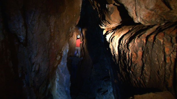 Person exploring a cave, Namibia