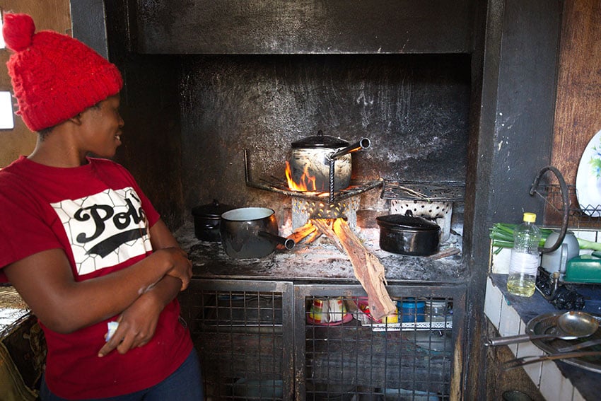 Junge Namibierin kocht Essen auf offenem Feuer, Namibia