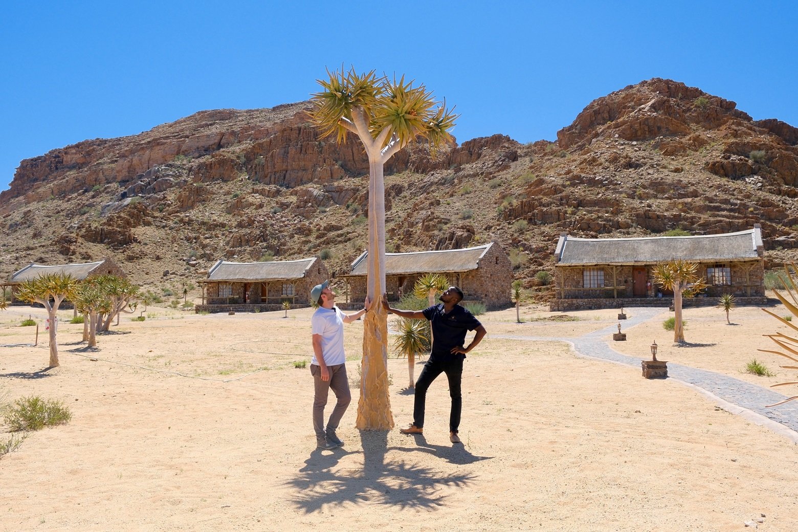 Mathias Tsameya (Gondwana Environmental and Social Impact Officer), Nick Murphy (Our Sustainable World)  with a quiver tree in Canyon Village, Namibia