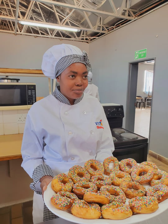 Woman holding donuts, Viktoria Namene Chef Apprentice at Gondwana Collection Namibia