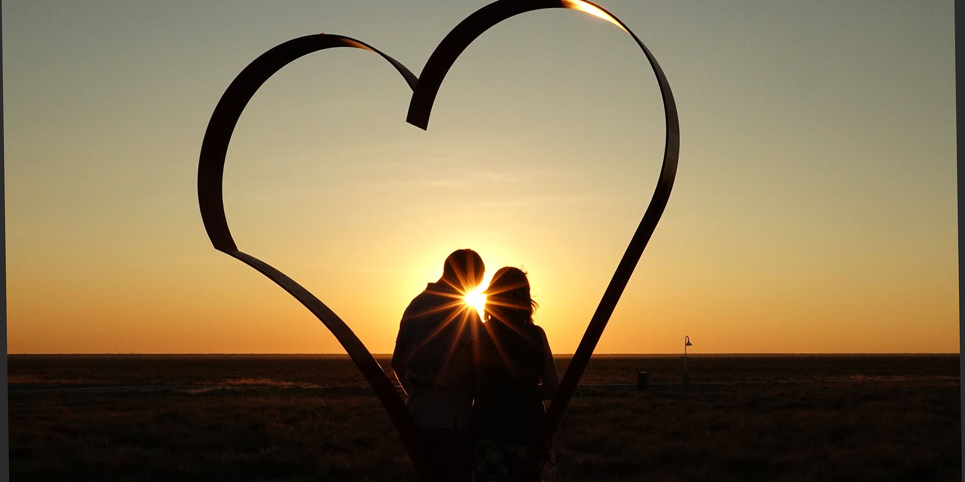 Kiss at sunset in a heart photo frame, Namibia