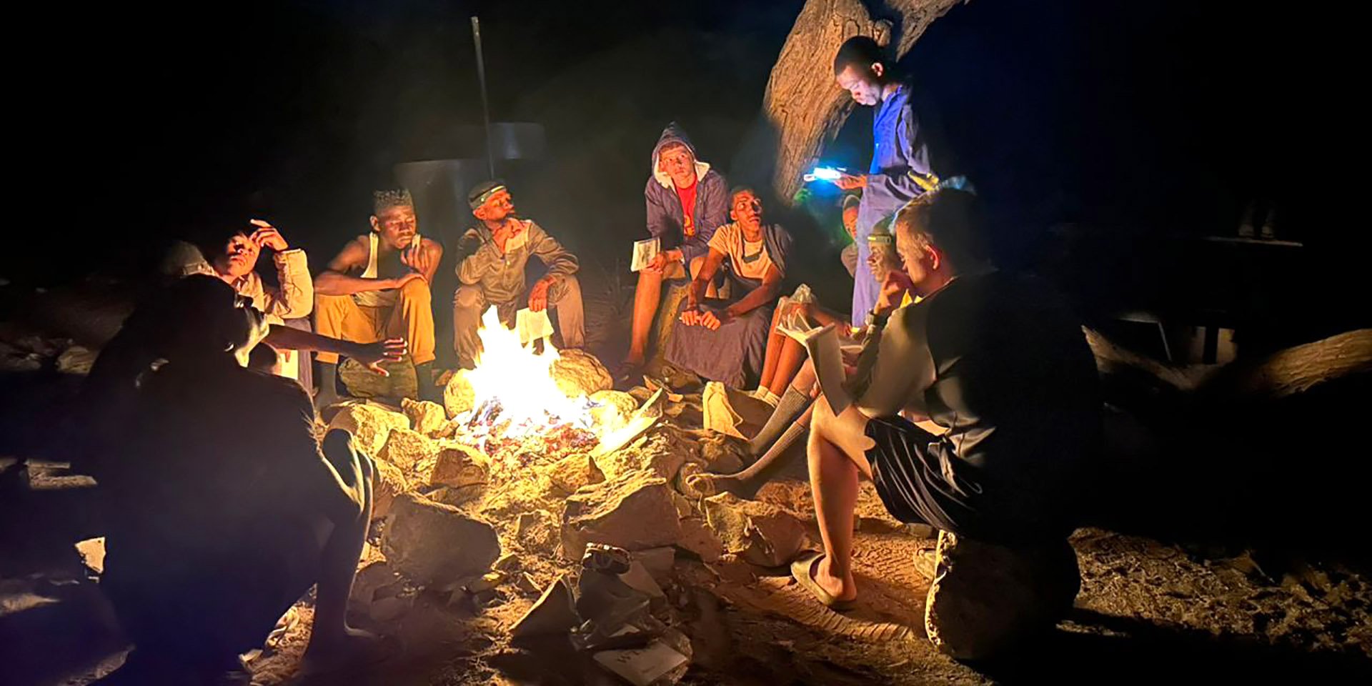 Namibians sitting around campfire