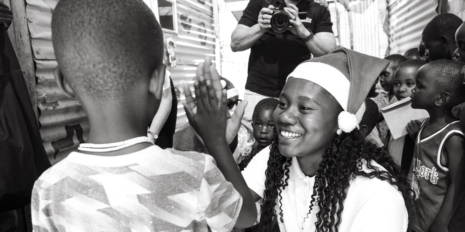 Namibian women with Santa hat and child, high five, Namibia