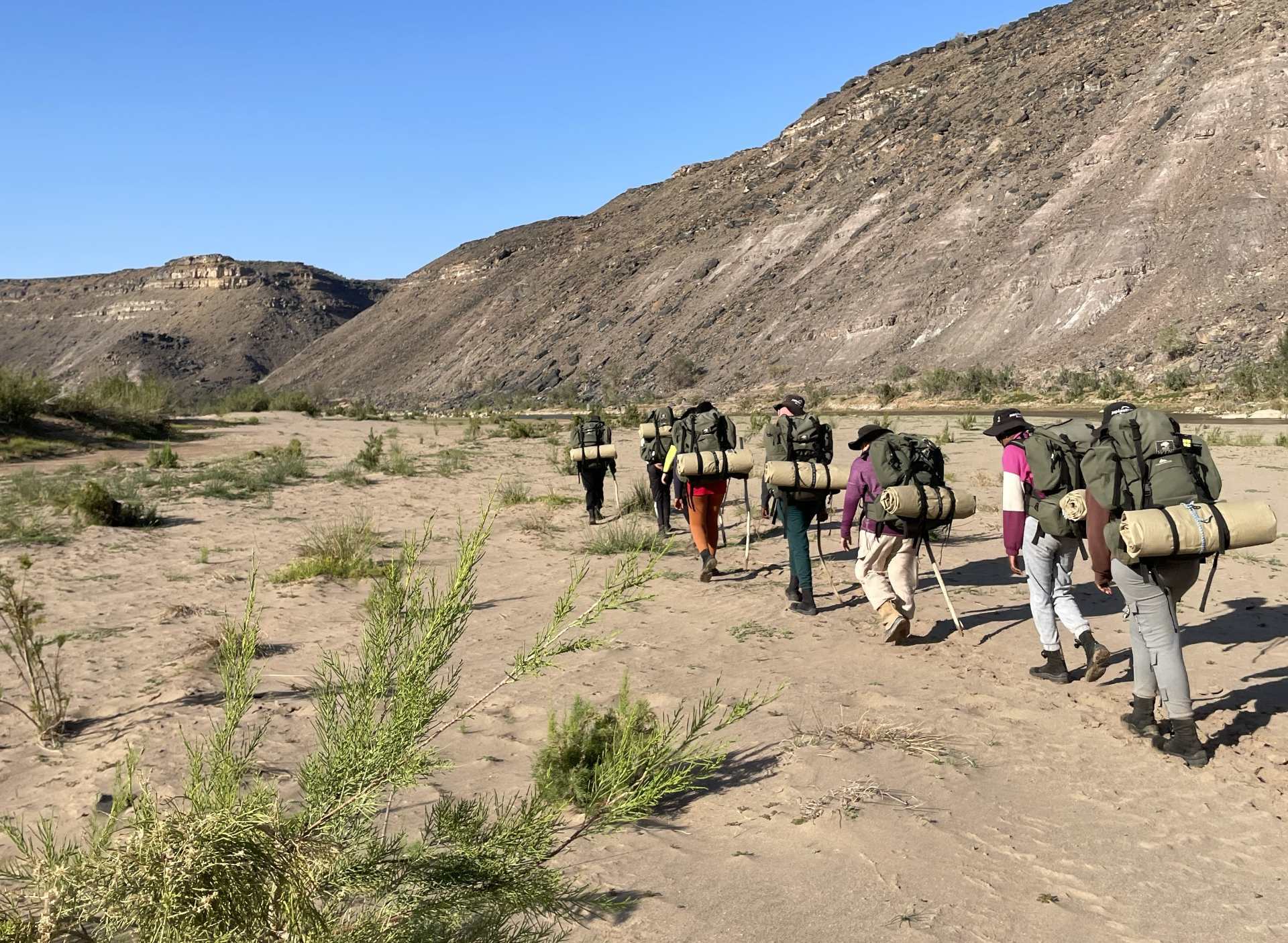 Young participants hiking through the Naukluft Mountains during a Wilderness Therapy Namibia programme