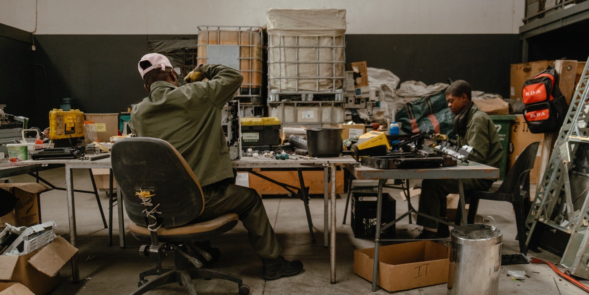 NamiGreen workers manually dismantling electronic waste to separate components like plastic and metal.