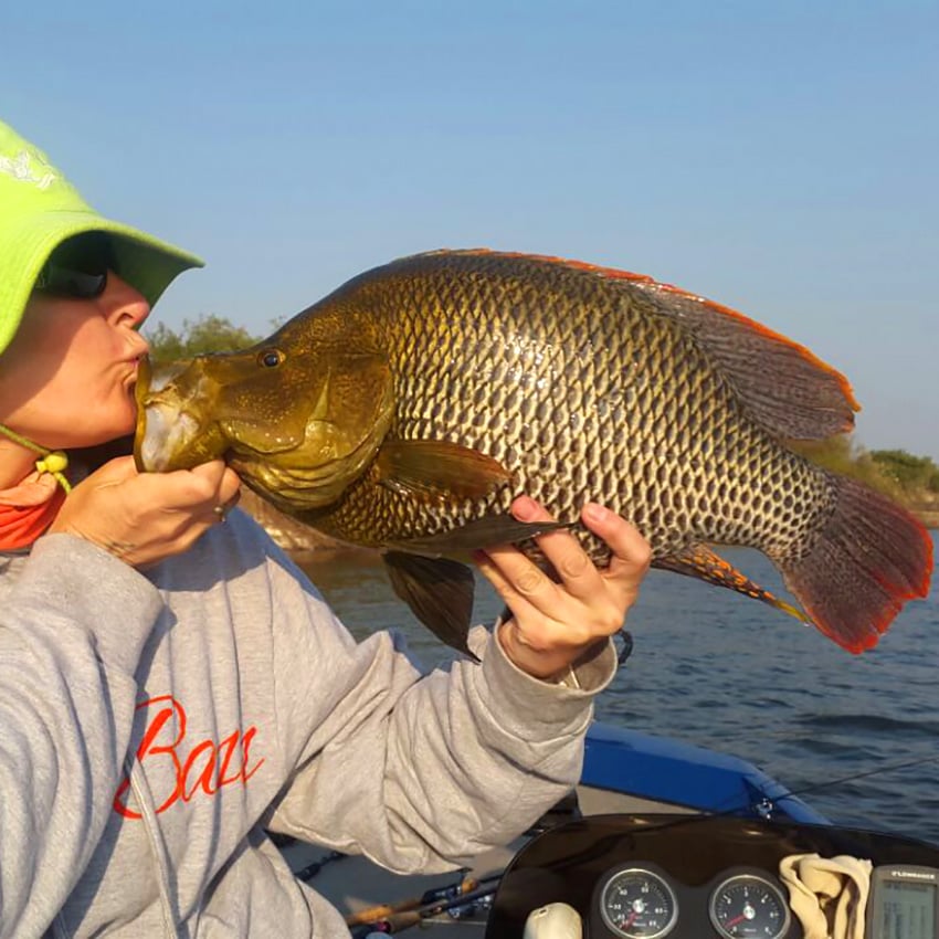 Angler kissing a freshly caught fish, Namibia