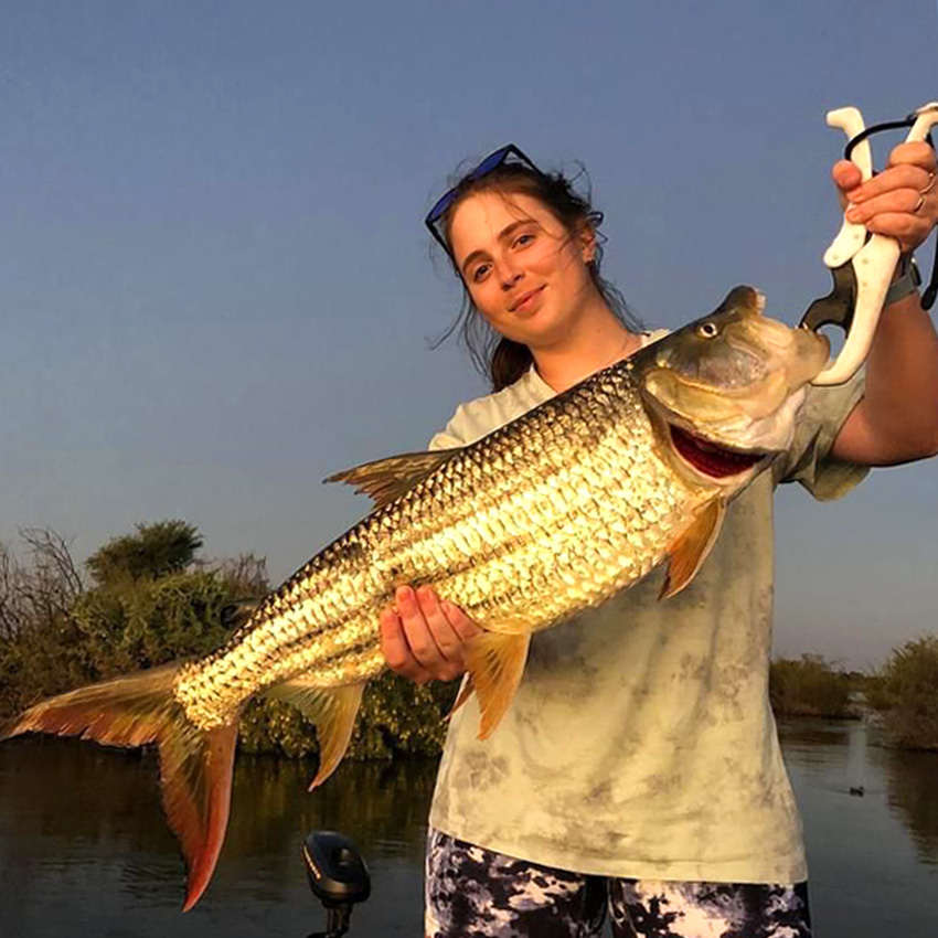 Young woman holding a tigerfish, Namibia