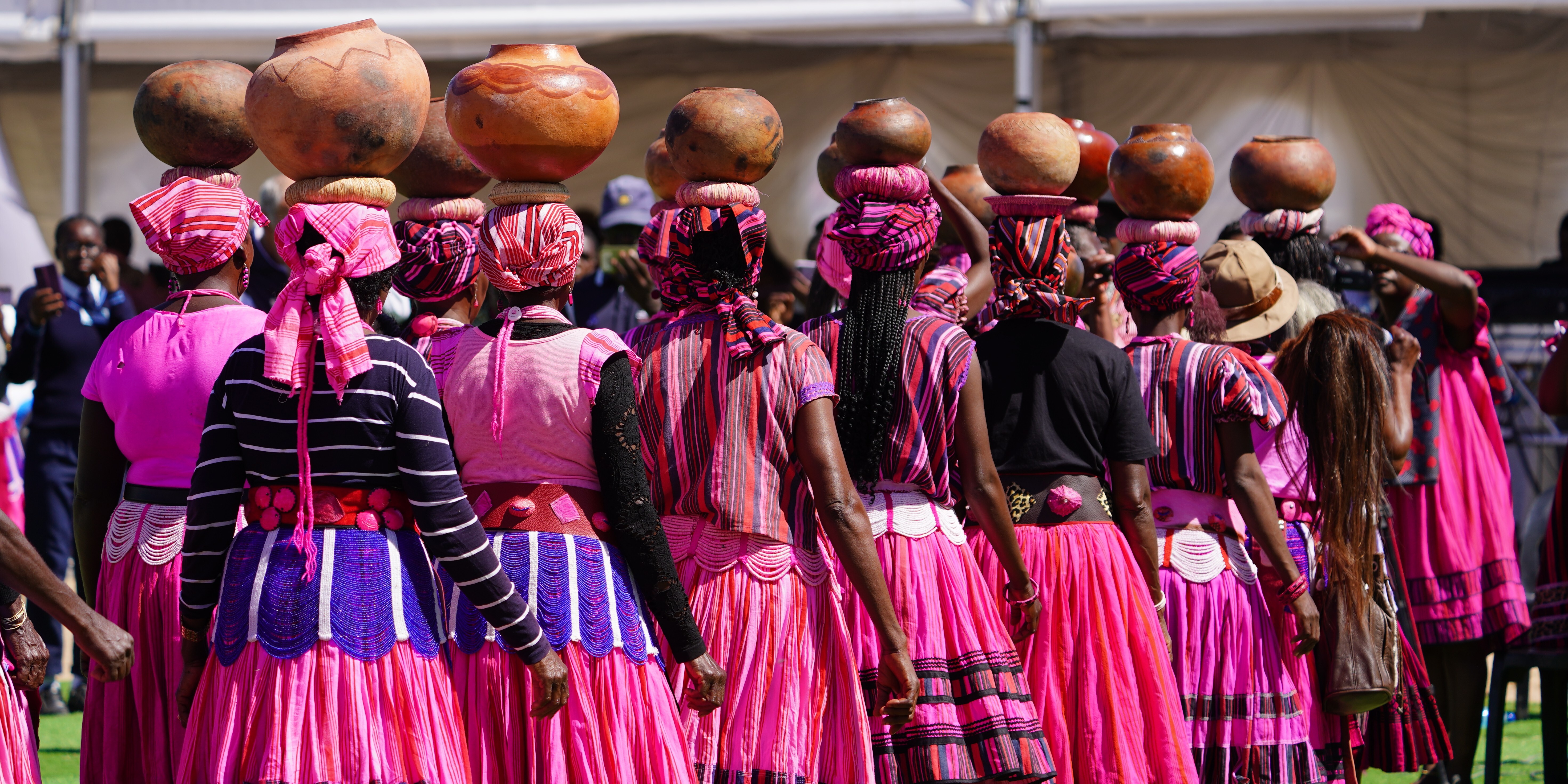 Owambo women carry clay pots with amarula juice at the Omagongo Festival, Namibia 
